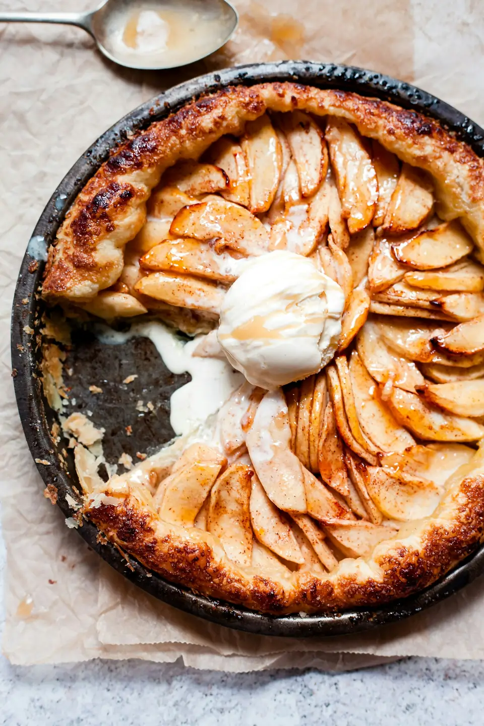 Tarte fine aux pommes en rosace, dorée, avec une boule de glace vanille